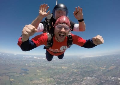 Two men smiling whilst skydiving